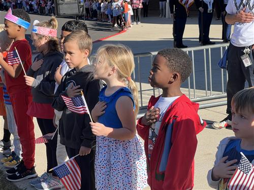 kids reciting pledge with hands over heart